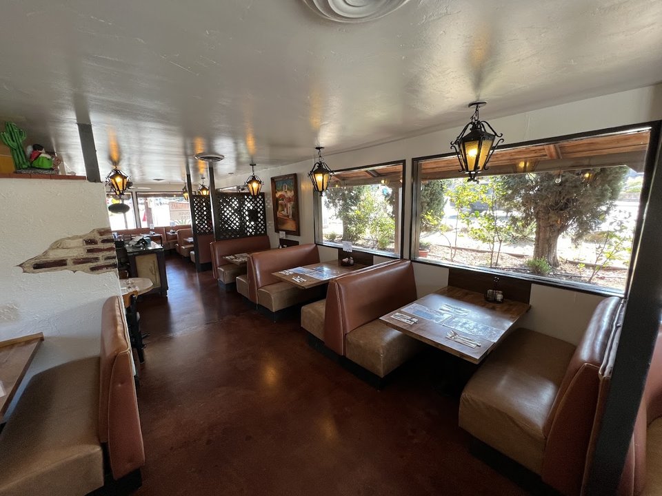Patio tables beside a cozy restaurant exterior.